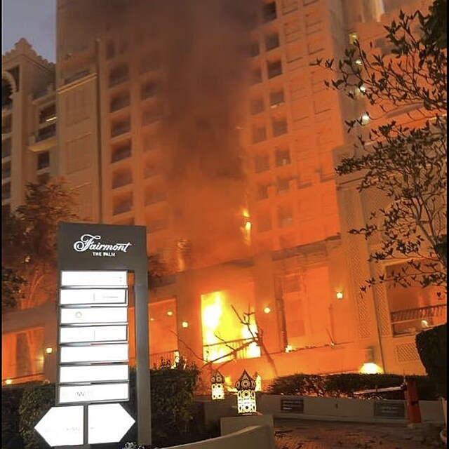 Plameny a ob�� sloup �ern�ho kou�e nad Palm Jumeirah. Dramatick� z�b�ry...