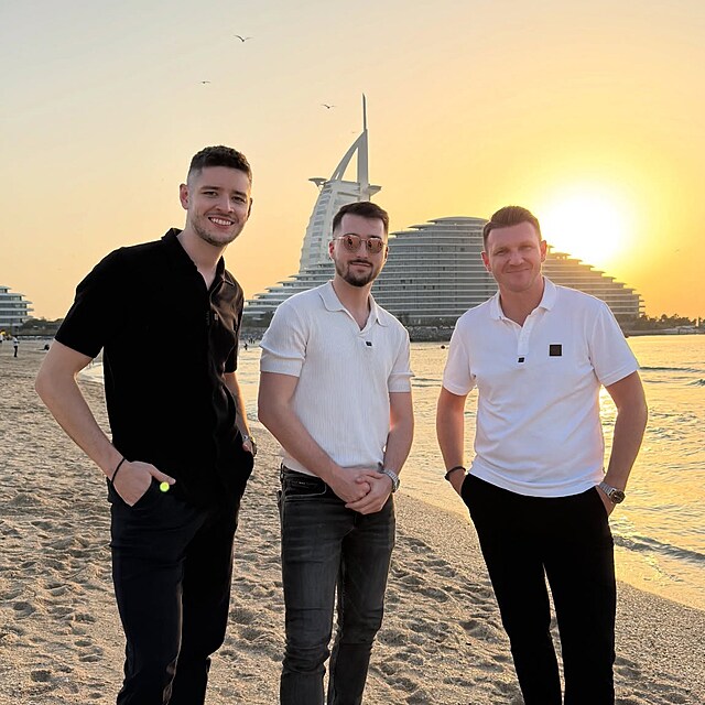 Ji�� Hanousek s kolegy v Dubaji na pl�i p�i z�padu slunce. V pozad� ikonick� hotel Burd� al-Arab.