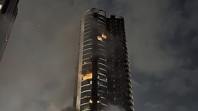 Po��r vysok� budovy v Dubaji po �toku. Plameny �lehaj� u pob�e�� a nad m�stem se val� hust� kou�.