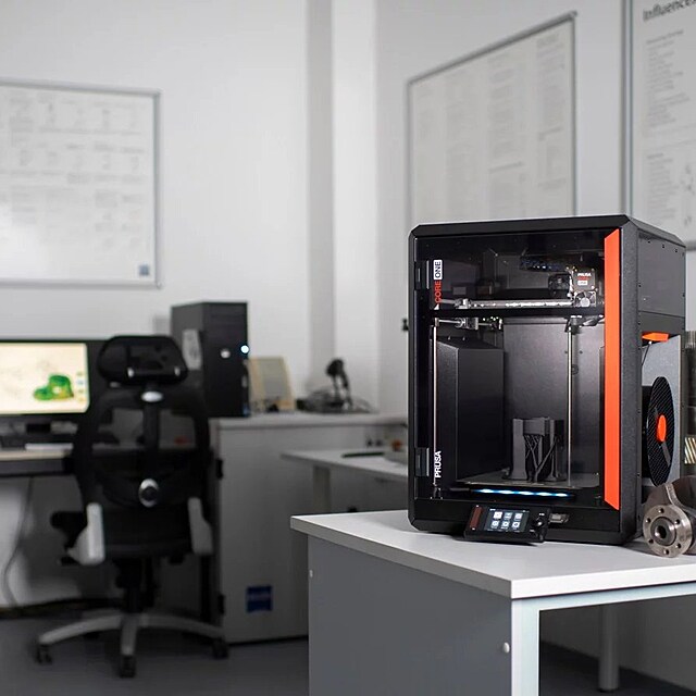 Tisk�rna Prusa Core One v pracovn�m prost�ed�. Dnes u� podobn� stroje stoj� nejen v gar��ch, ale i v kancel���ch nebo design�rsk�ch studi�ch.