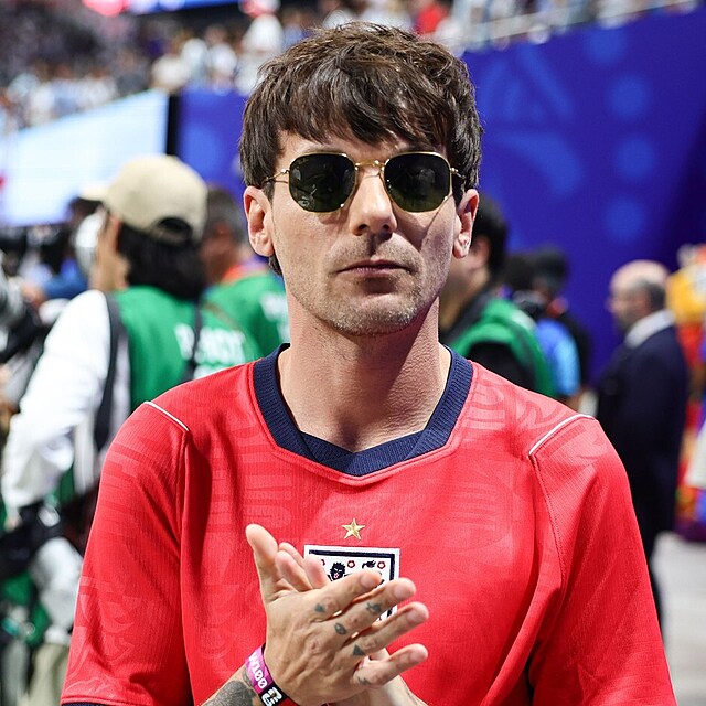 B�val� �len kapely One Direction Louis Tomlinson dorazil na stadion v �erven�m dresu