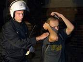 Policista odvádí skina