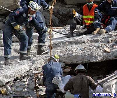 Záchranái hledají obti zemtesení v troskách budovy Margala Towers v Islámábádu.