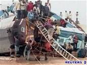 Lidé lezou po potopených vagónech po elezniní netstí v jihoindickém stát Ándhrapradé.