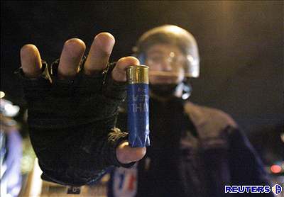 Francouzský policista ukazuje jeden z náboj vypálených výtrníky.
