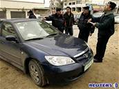 Palestintí policiste prohlíejí vozidlo unesených uitel v Gaze.