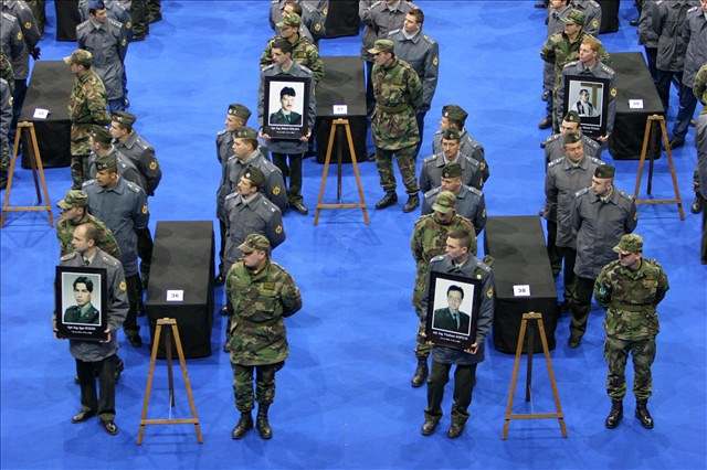 Vojáci dreli pi pietním rozlouení fotografie zesnulých.