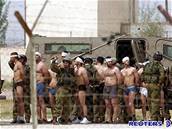 Izraeltí vojáci nakládají na auta svázané palestinské vzn