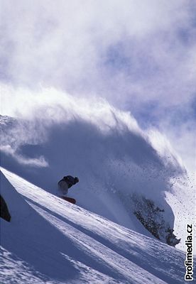 Snowboardista v terénu, v pozadí lavina