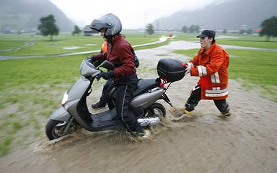 Hasi u výcarského Stans pomáhá motocyklistce z rozvodnné eky.