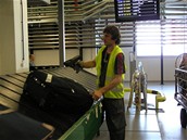 Karusel - pracovník handlingu skenuje zavazadlo