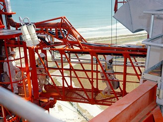 Kosmonauti přecházejí můstkem z obslužné věže do své kabiny