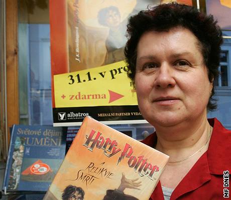 Vladimíra Fišerová instaluje do výlohy makety české verze knihy Harry Potter a Relikvie smrti