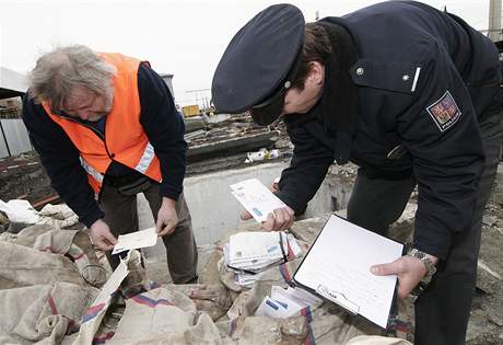 Policista prohlíží s pracovníkem nádraží v Břeclavi nalezenou poštu.
