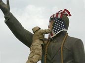 Pt let války v Iráku - Voják zakrývá sochu Saddáma Husajna americkou vlajkou....