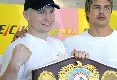 Boxer Luká Konený se svým trenérem Dirkem Dzemskim se symbolickým pásem pro mistra svta WBO