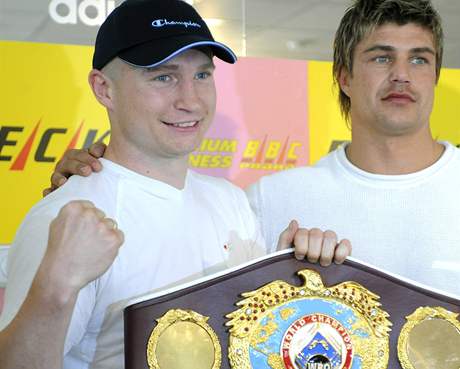 Boxer Luká Konený se svým trenérem Dirkem Dzemskim se symbolickým pásem pro mistra svta WBO