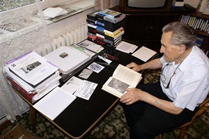 Adolf Burger ve své pracovně listuje prvním vydáním své knihy o zážitcích z koncentračního tábora 
