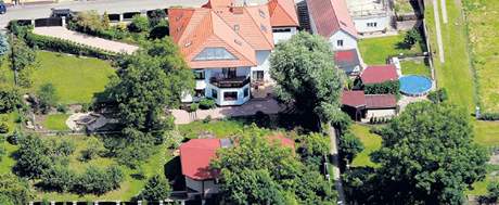 Poslanec Vlastimil Tlustý loni prodal za dva miliony korun byt v Praze-Hodkovikách a poídil si na zahrad u své vily ve Slaném bazén za 1,8 milionu. Jde o zasteený objekt na snímku dole uprosted.