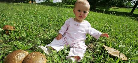 Kristýnka Lukáková sedí mezi houbami, které vyrostly uprosted návsi ve Hvzdlicích na Vykovsku