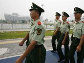 �ín�tí policisté hlídkují u pekingského olympijského stadionu.