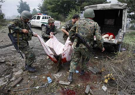 Vojáci odnáejí tlo po bombardování msta Gori