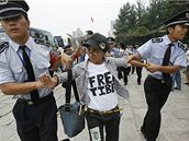 P�íslu�níci bezpe�nosti odvád�jí protestující od brány parku v Pekingu (13. srpna 2008)