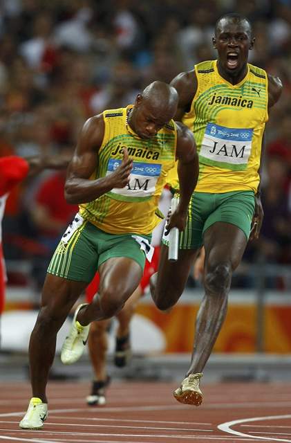 Poslední pedávka jamajské tafety: Bolt pedává Powellovi.