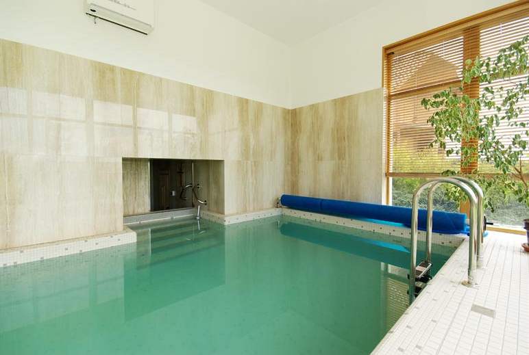 Bazén je pímo propojen s ochlazovacím bazénkem sauny, stny pokrývá pírodní kámen