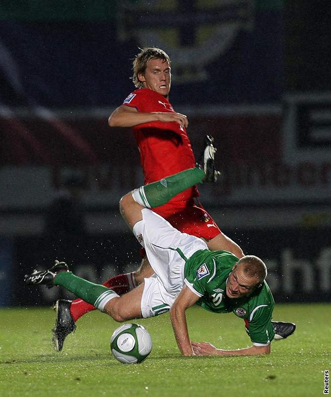 eský fotbalista Radoslav Ková (v erveném) v souboji se severoirským soupeem Warrenem Feeneym. 