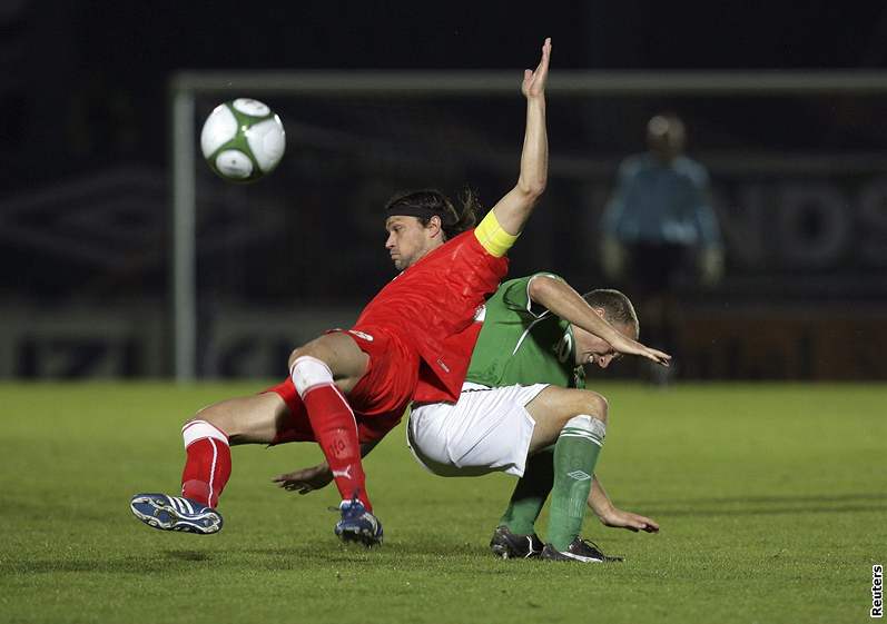 Kapitán eských fotbalist Tomá Ujfalui padá na trávník pi souboji s Warrenem Feeneym, reprezentantem Severního Irska. 