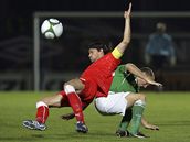 Kapitán eských fotbalist Tomá Ujfalui padá na trávník pi souboji s Warrenem Feeneym, reprezentantem Severního Irska. 