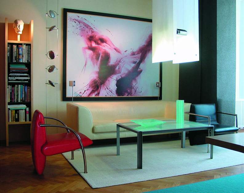 Obývací pokoj s minimem nábytku a projektorem skrytým za textilií