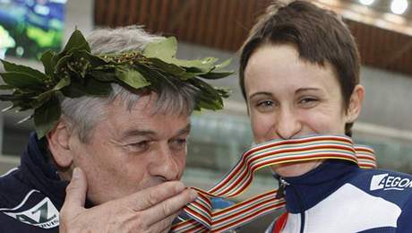Martina Sáblíková se zlatou medailí, kterou líbá její kou Petr Novák.