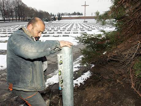 Ivan Lovsz z firmy Trade Fides instaluje sloupek na osvtlen hbitova
