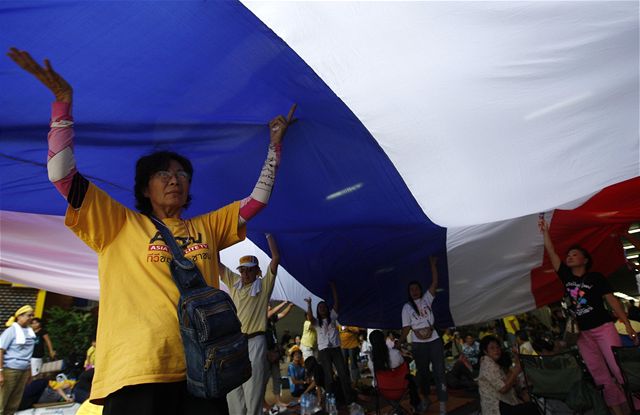 Protivládní demonstranti drí na uzaveném letiti Don Muang v Bangkoku nad hlavami thajskou vlajku. (27.11.2008)