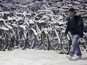Mladík v Curychu prochází kolem bicykl pokrytých snhem