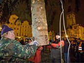 Dlníci se chystají ukotvit devadesátiletý vánoní smrk do pipraveného otvoru na Straromstském námstí