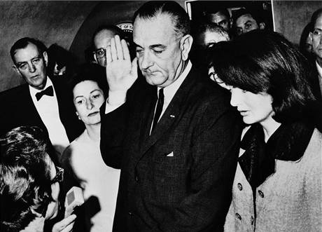 Lyndon Johnson skld prezidentskou psahu po zavradn JFK. Vedle stoj Jackie Kennedyov. 