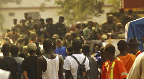 Lidé sledují vojenské hlídky v ulicích guinejské metropole Conakry. 