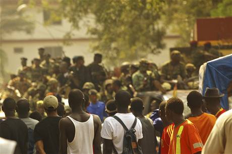 Lidé sledují vojenské hlídky v ulicích guinejské metropole Conakry. 