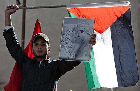 Protestujc v jordnskm tboe Bika dr palestinskou vlajku a portrt nkdejho irckho prezidenta Husejna a palestinskho vdce Arafata. (28. prosince 2008)