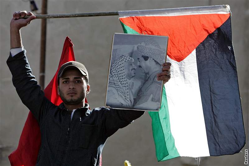 Protestující v jordánském táboe Bikáa drí palestinskou vlajku a portrét nkdejího iráckého prezidenta Husejna a palestinského vdce Arafata. (28. prosince 2008)
