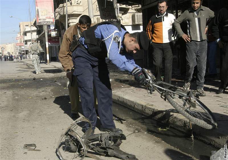 Policista ohledává zbytky bicyklu, na kterém vjel sebevraedný atentátník do davu protestujících v Mosulu. (28. prosince 2008)
