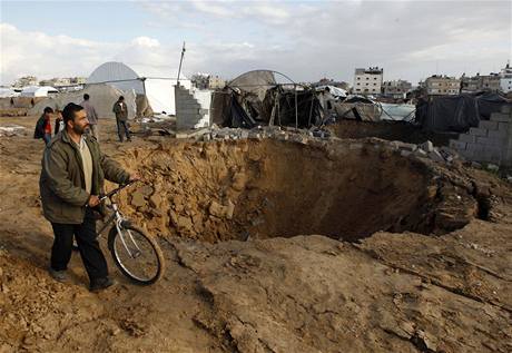 Palestinec obchází kráter po vybombardovaném tunelu v pásmu Gazy