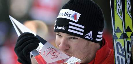 výcar Dario Cologna líbá trofej pro vítze Tour de Ski