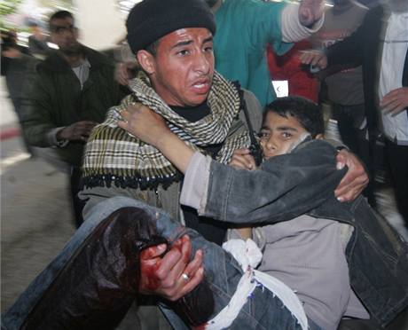 Palestinec nese chlapce zranného bhem izraelské pozemní operace v Gaze (4. leden 2009)