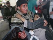 Palestinec nese chlapce zranného bhem izraelské pozemní operace v Gaze (4. leden 2009)