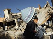 Palestinec sbírá listy z Koránu poté, co Izraelské bomby zniily meitu v Rafáhu na jihu pásma Gazy.