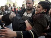 Palestinci odnáejí zranné po výbuchu izraelské bomby.